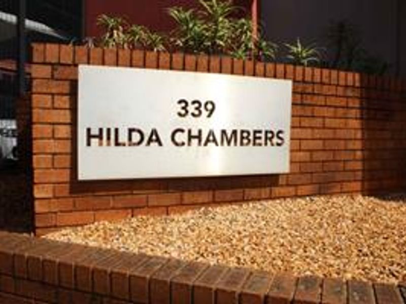 Exterior view of the brick boundary wall featuring the metal signage for Hilda Chambers at 339.