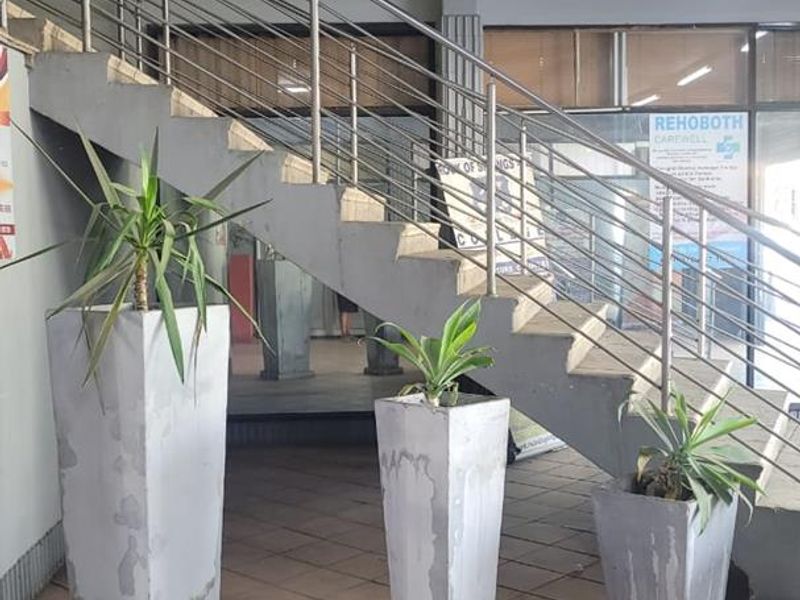 Entrance area featuring a concrete staircase with stainless steel railings and tiled flooring, providing access to the commercial premises.