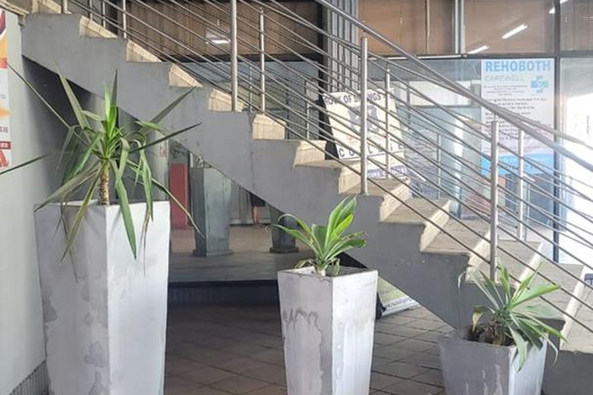 Entrance area featuring a concrete staircase with stainless steel railings and tiled flooring, providing access to the commercial premises.
