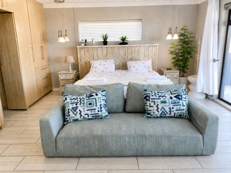 A well-maintained bedroom featuring built-in wardrobes, tiled flooring, and direct access to an outdoor area through a sliding glass door.