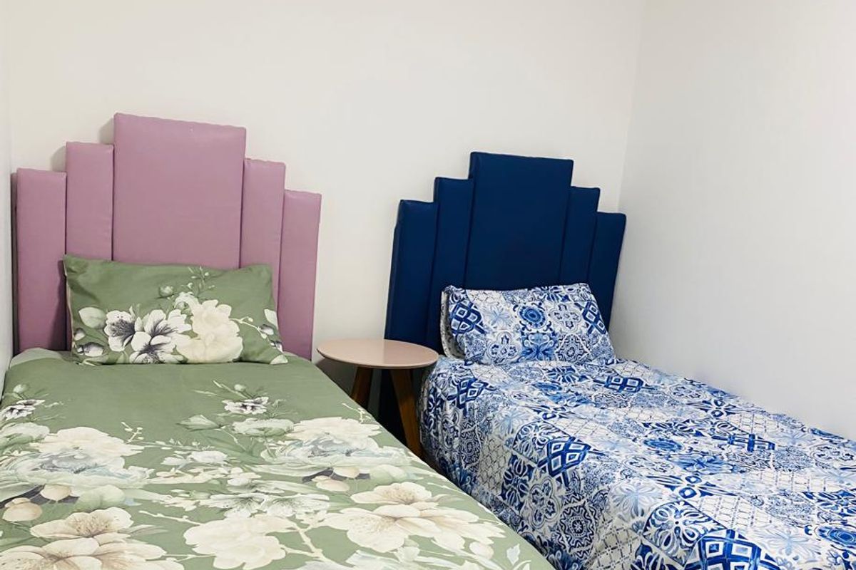A bedroom featuring neutral walls and standard ceiling finishes, currently configured with two single beds.