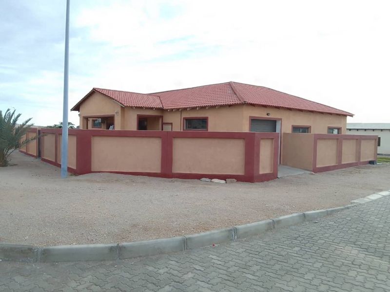 A single-story residential house featuring a tiled roof, perimeter wall, and paved driveway, presenting a neat and well-maintained exterior facade.