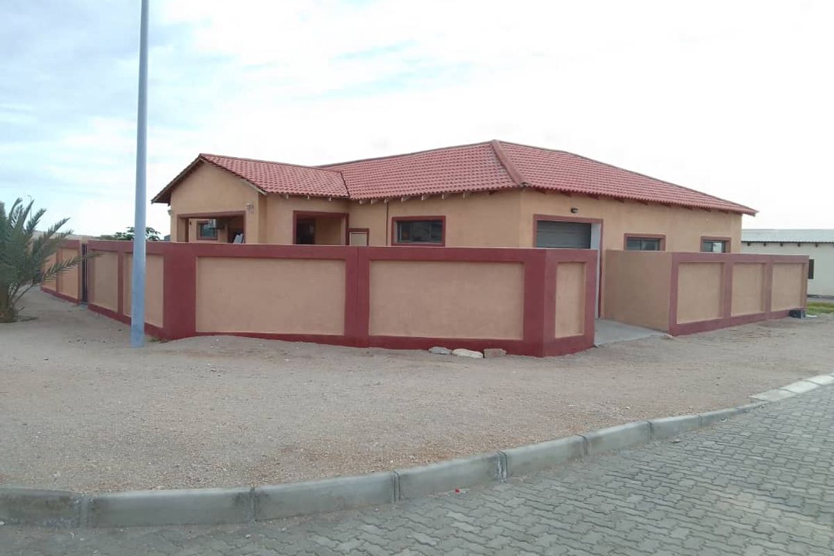A single-story residential house featuring a tiled roof, perimeter wall, and paved driveway, presenting a neat and well-maintained exterior facade.