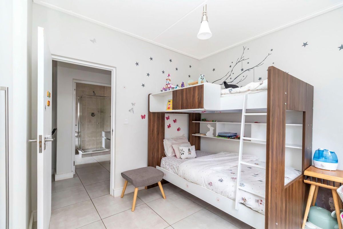 A well-maintained bedroom featuring tiled flooring and direct access to an en-suite bathroom.