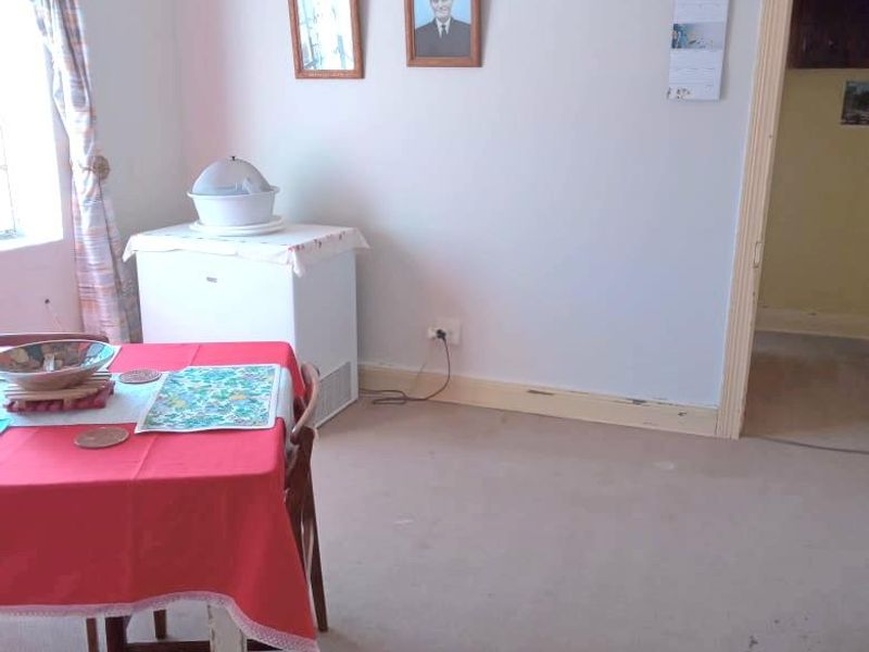 A dining area featuring neutral walls, a picture rail, and carpeted flooring, offering a blank canvas for potential interior updates.