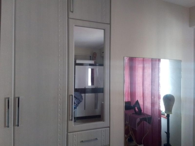 Bedroom featuring built-in wardrobes with integrated mirror panels and an additional wall-mounted mirror.