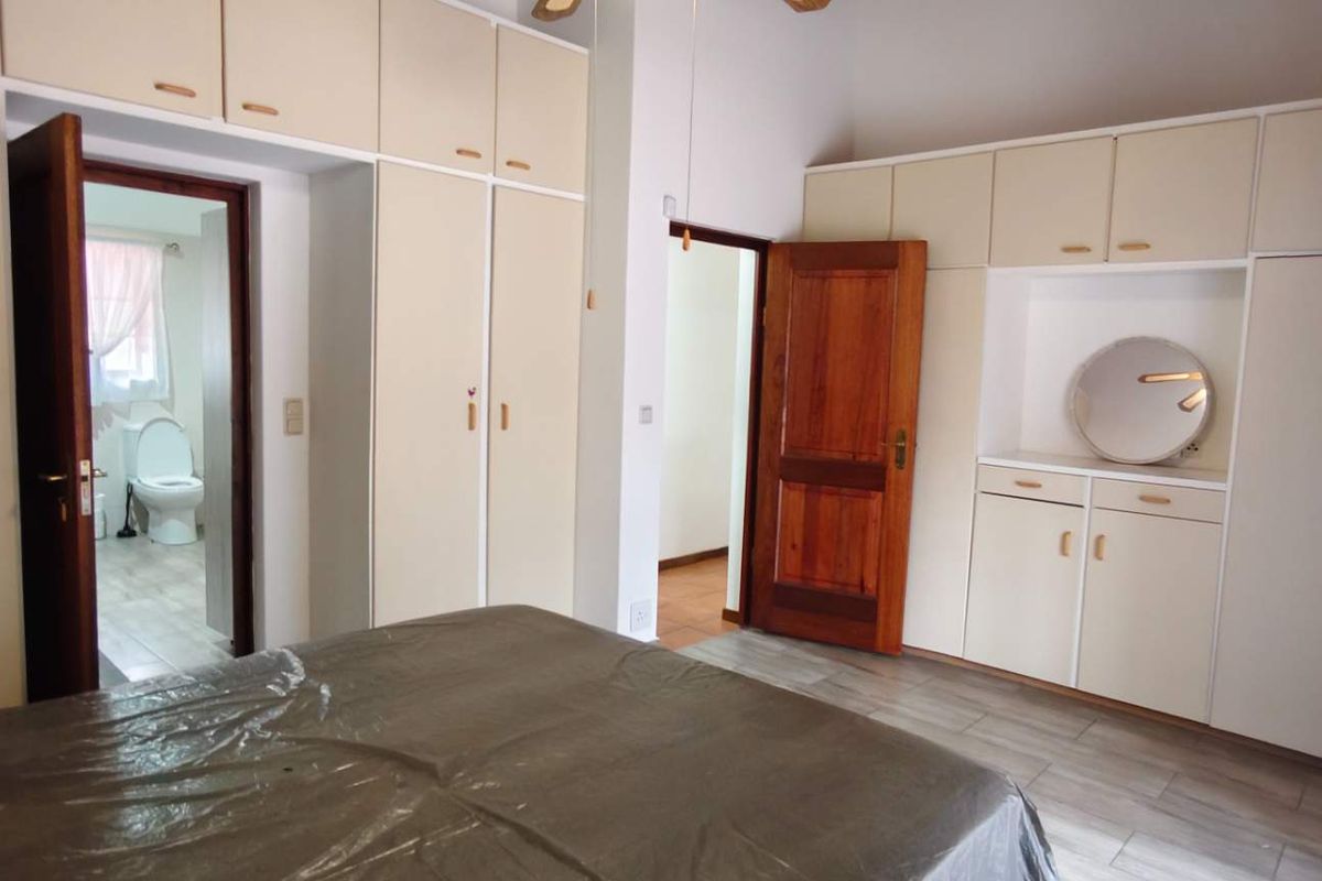 A bedroom featuring extensive built-in cabinetry with overhead storage and direct access to an en-suite bathroom.