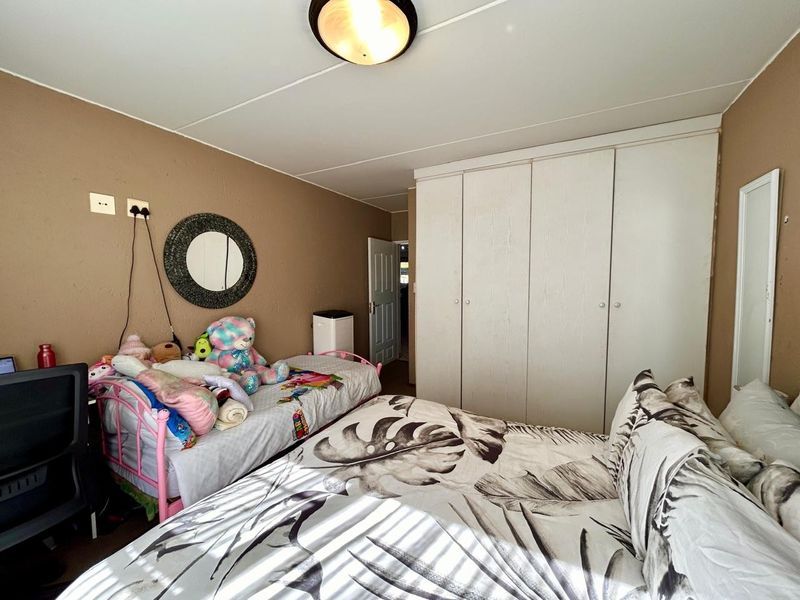 A bedroom featuring built-in cupboards and a flush mount ceiling light, providing functional storage and lighting within the space.