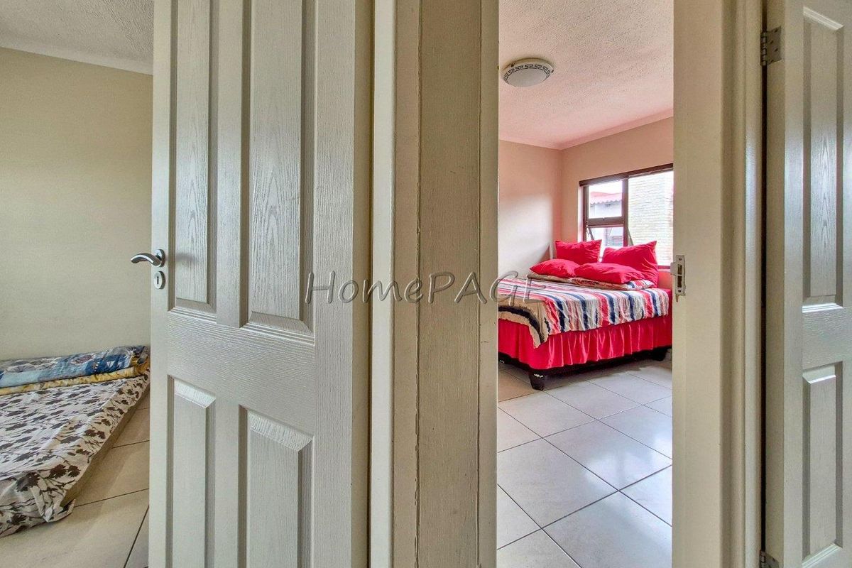 A view through a doorway into a bedroom featuring tiled flooring and a flush-mount ceiling light fixture.
