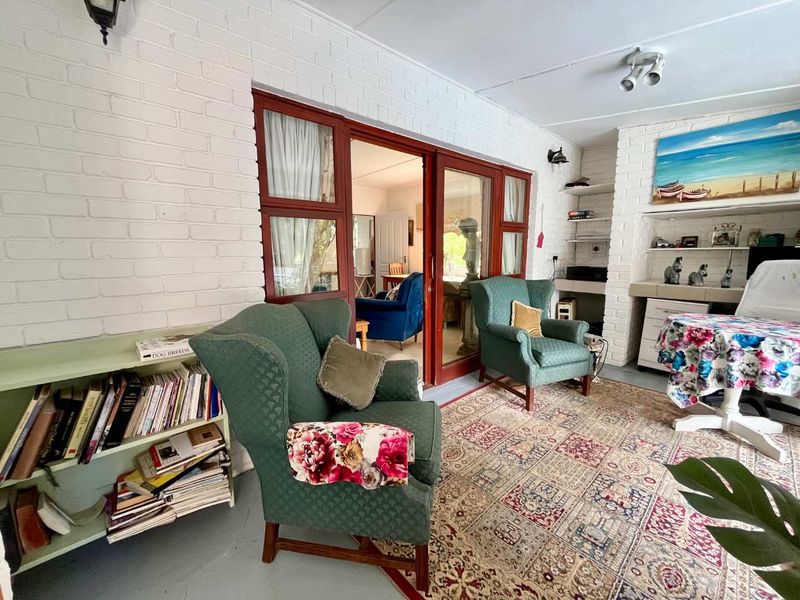 A covered patio area featuring painted brick walls, built-in shelving, and sliding glass doors providing access to the interior living space.