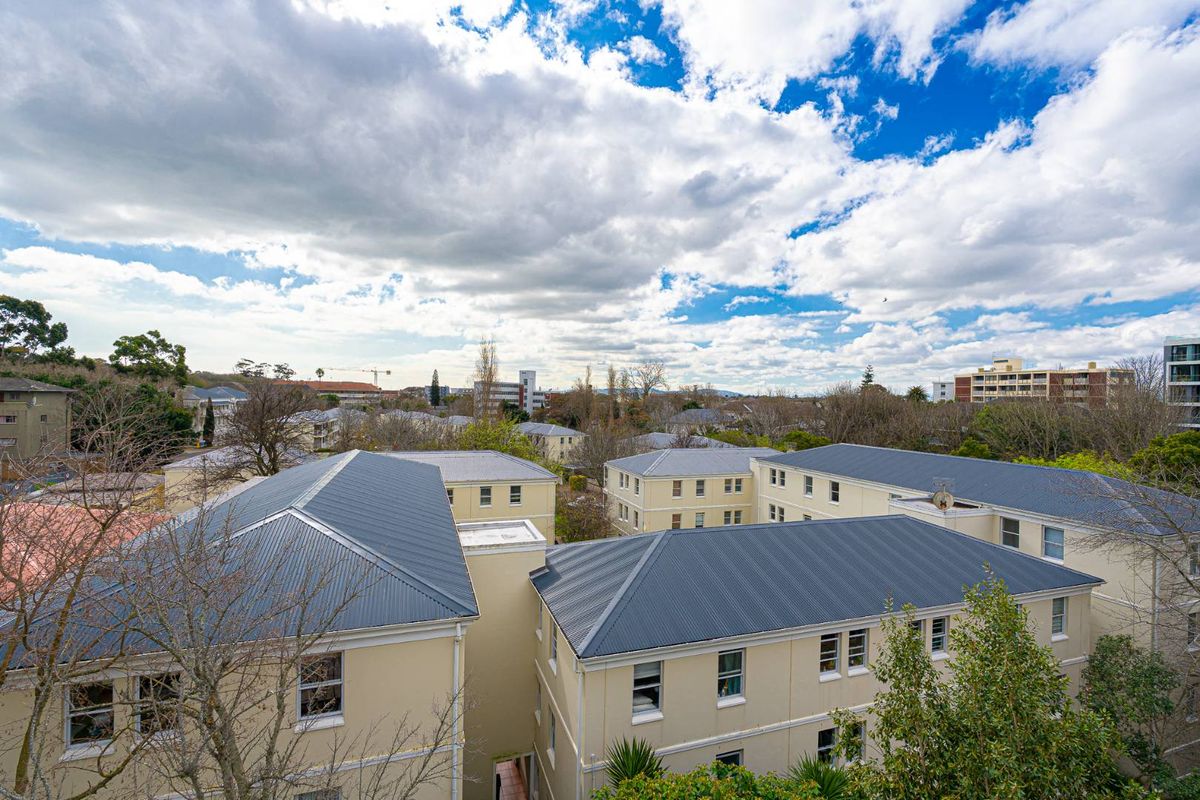 Elevated aerial view overlooking the apartment complex rooftops and surrounding neighbourhood landscape.