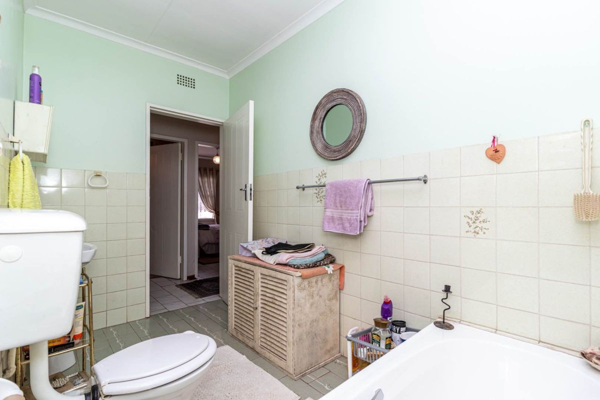 A functional bathroom featuring a standard bathtub, toilet, and tiled wall finishes, providing a practical layout for a townhouse residence.