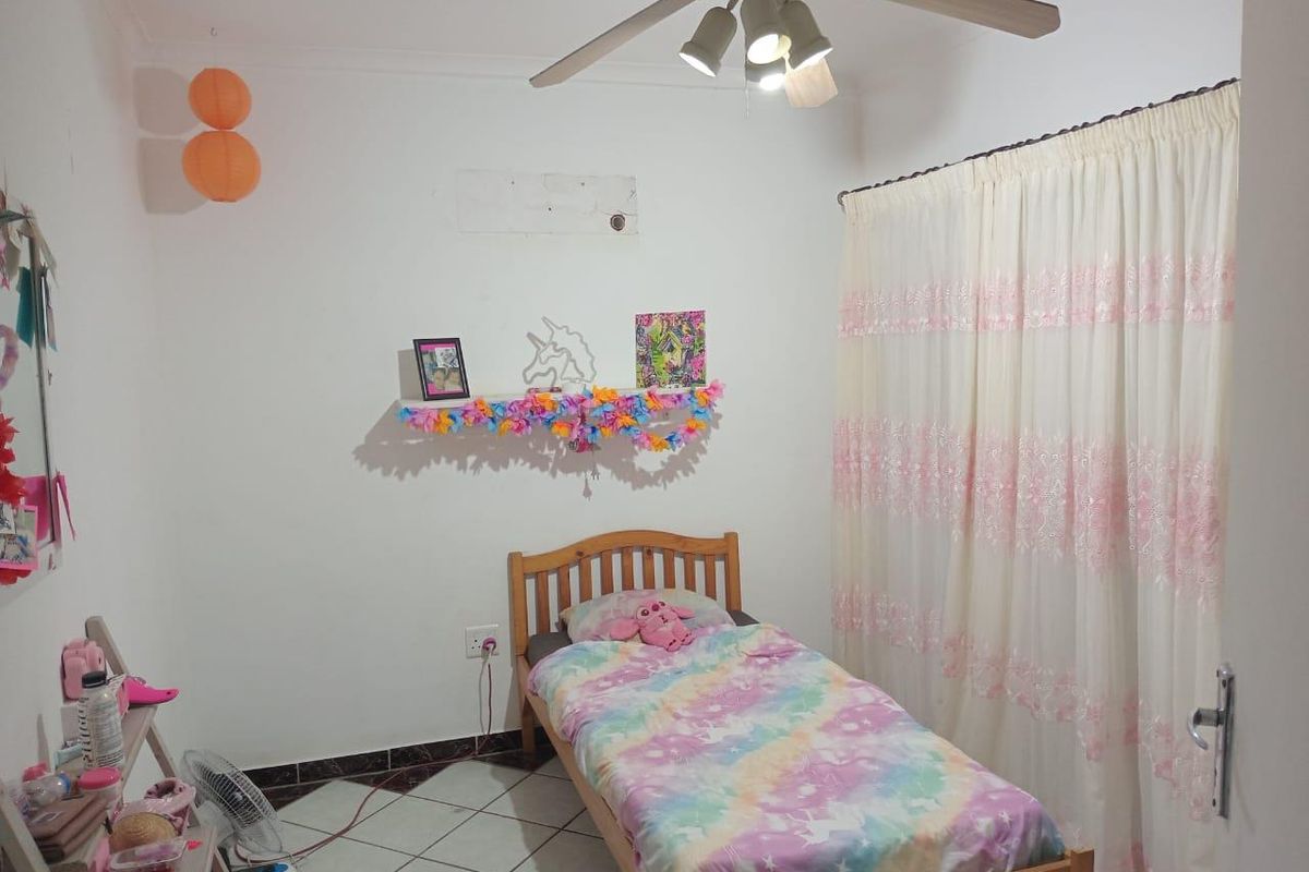 A bedroom featuring tiled flooring, a ceiling fan, and a window covered by curtains.