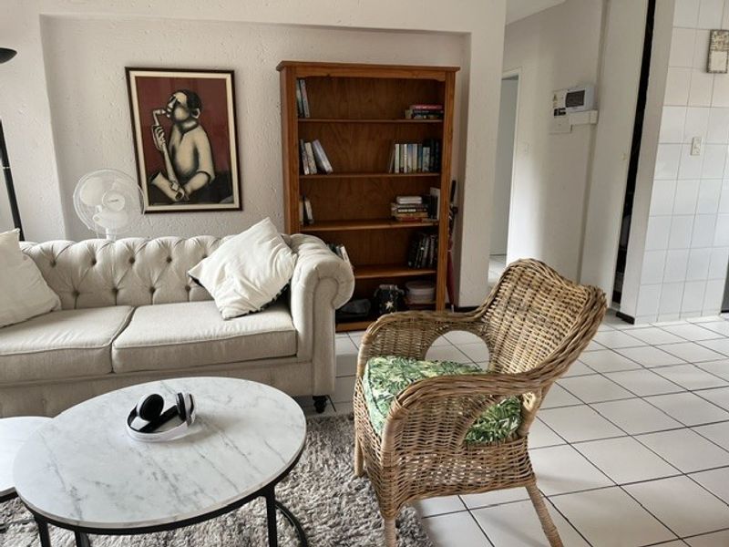 A living room area featuring white tiled flooring and a recessed wall niche, providing a neutral foundation for various interior design styles.
