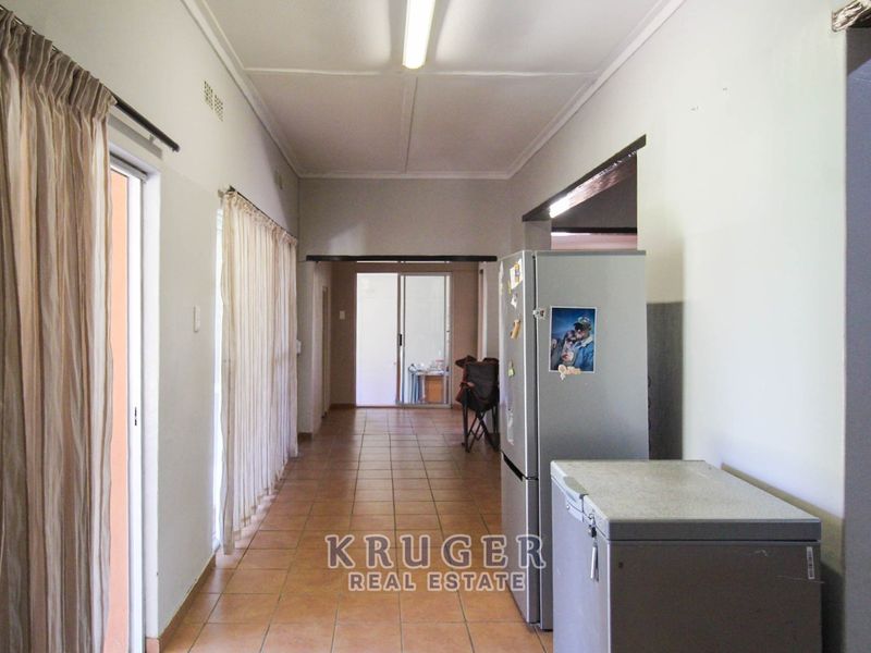 A functional hallway featuring tiled flooring and sliding glass doors providing access to outdoor areas, with neutral wall finishes.