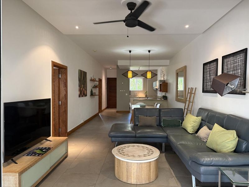 An open-plan living and kitchen area featuring tiled flooring, recessed lighting, a ceiling fan, and modern kitchen cabinetry.