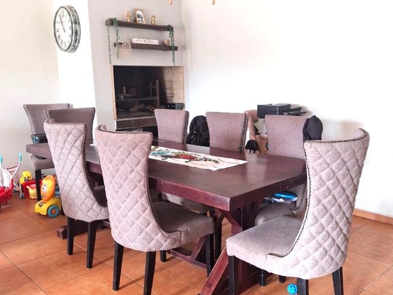 Dining area featuring tiled flooring, a ceiling fan, and a built-in fireplace.