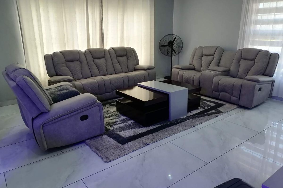 A well-maintained living room featuring modern large-format floor tiles and neutral wall finishes, providing a clean and comfortable space.