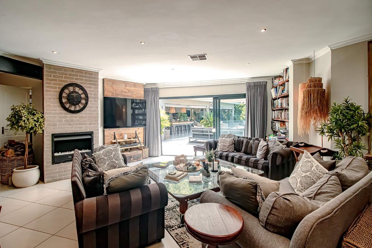 Spacious living room featuring a built-in fireplace with brick surround, recessed lighting, and large sliding glass doors opening to an outdoor patio area.