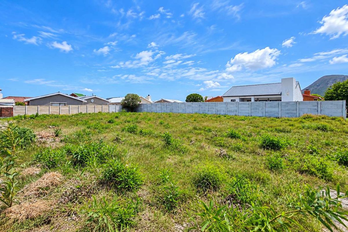 A vacant residential plot of land featuring a precast concrete boundary wall, ready for development in a established neighbourhood.