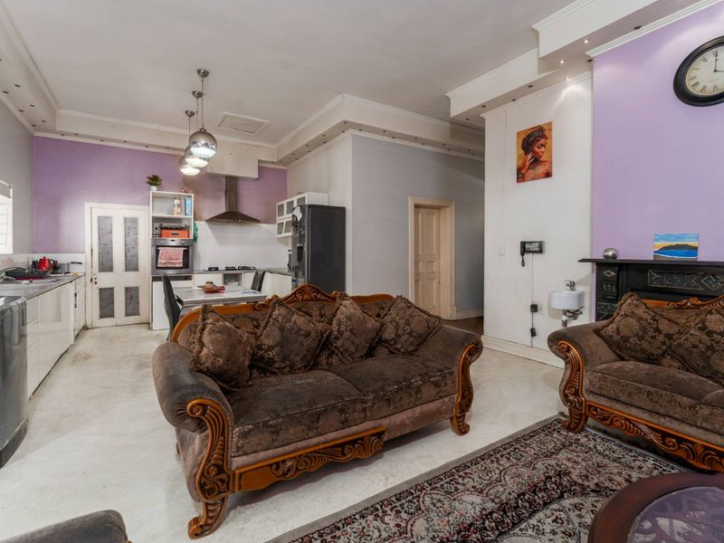 Open-plan living and kitchen area featuring a fireplace, built-in oven, and gas hob, offering a versatile space for cooking and relaxation.
