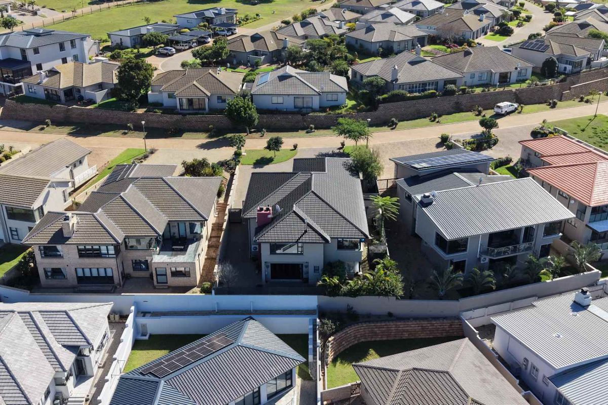 Aerial view of a residential property within a suburban estate, showcasing the roof structure, solar panel installation, and surrounding neighborhood layout.