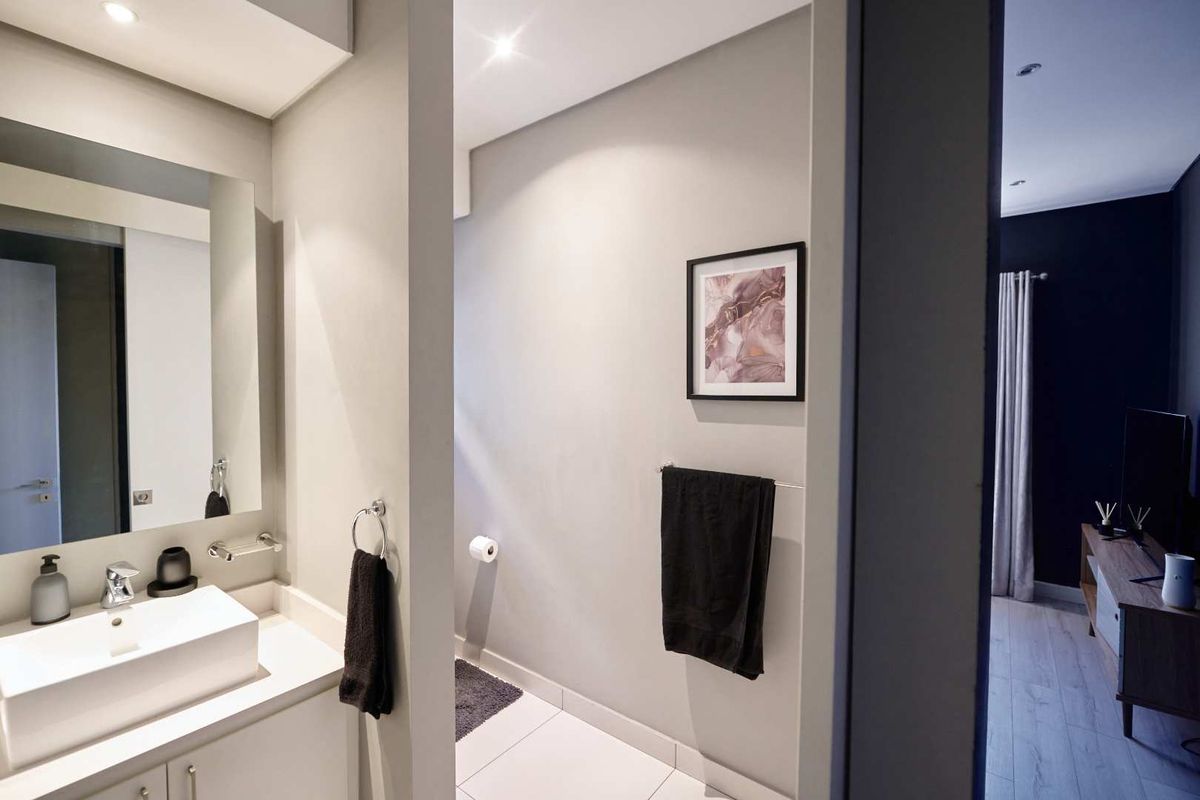 Modern bathroom featuring a sleek vessel sink, vanity cabinet, and wall-mounted mirror, with a clean, contemporary aesthetic and neutral color palette.