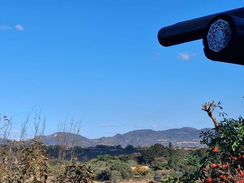 A scenic elevated view of the surrounding landscape and distant mountains, framed by a wooden structural beam.