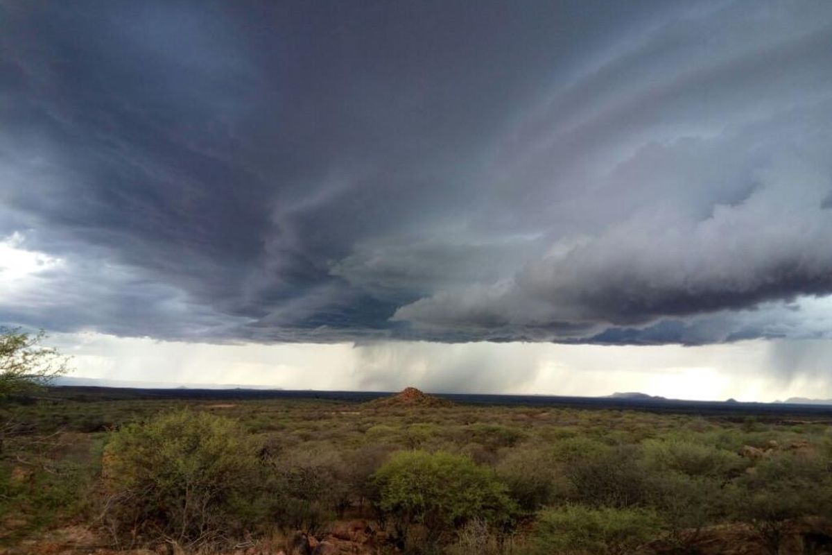 A scenic landscape view of the surrounding small holding terrain under a dramatic stormy sky.
