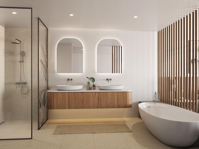 Modern luxury bathroom featuring a floating double vanity, arched backlit mirrors, a freestanding soaking tub, and a walk-in shower with decorative glass paneling.