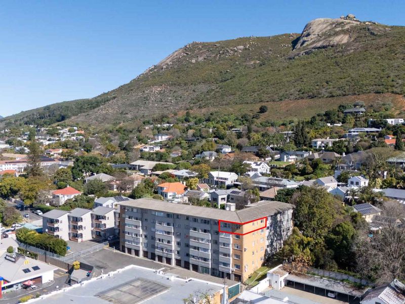 Aerial view of an apartment complex situated in a residential neighborhood with mountain views.