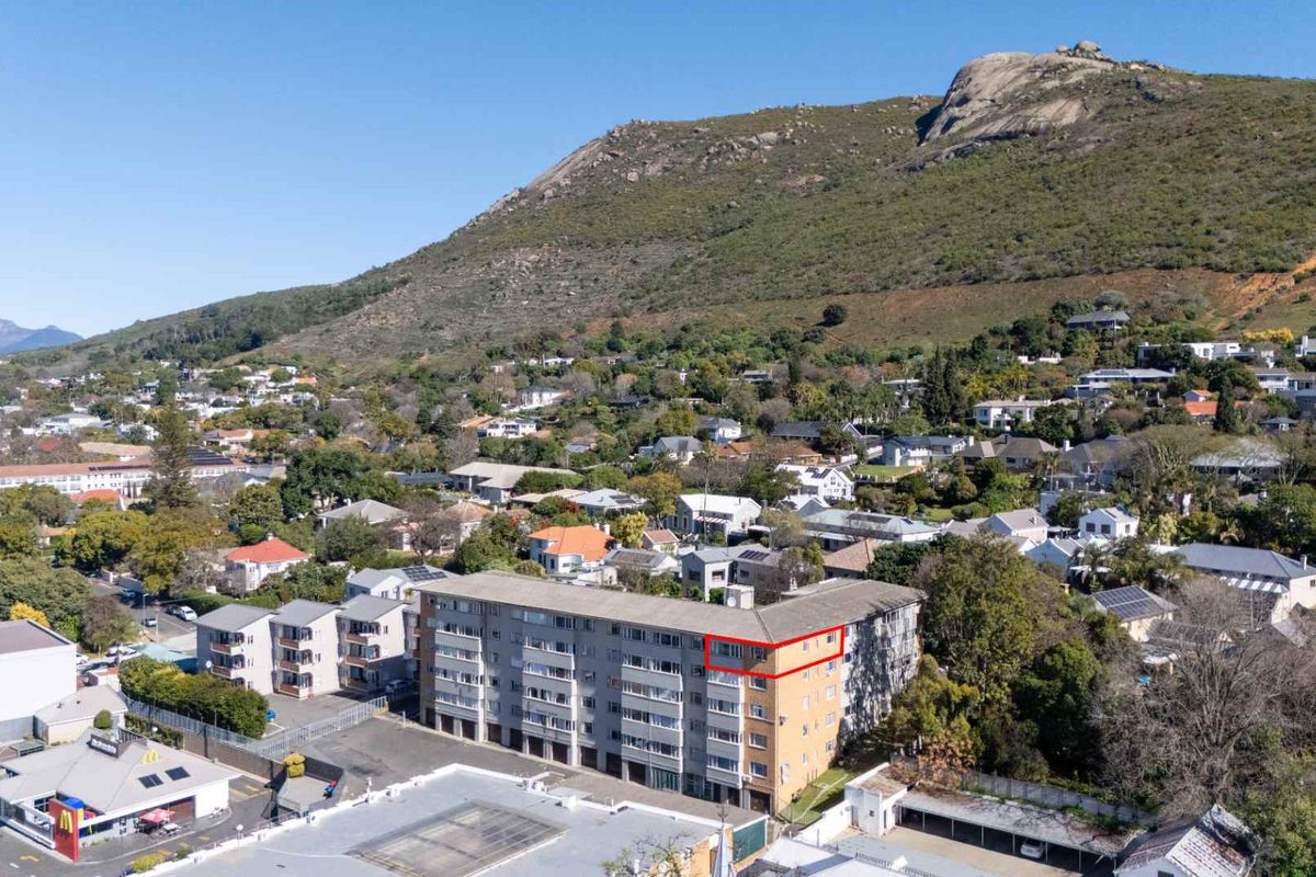 Aerial view of an apartment complex situated in a residential neighborhood with mountain views.