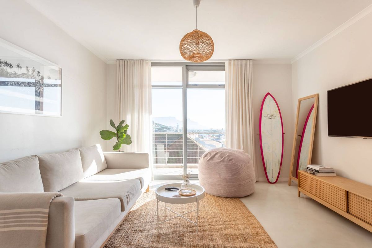 Bright and airy living room featuring large sliding glass doors that open onto a private balcony with scenic views.