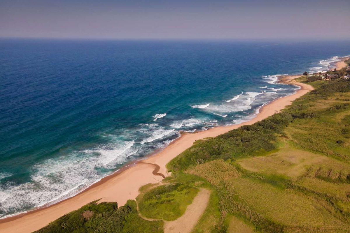 An aerial view of the coastal residential land, showcasing direct beach access and expansive ocean views.