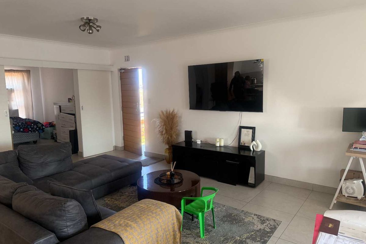 A living room featuring tiled flooring, a ceiling light fixture, and a direct entrance door leading to the exterior.
