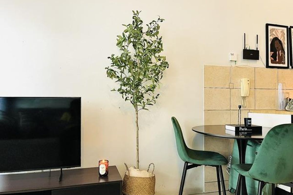 A living area featuring a neutral wall with a decorative tiled accent section and a wall-mounted intercom system.