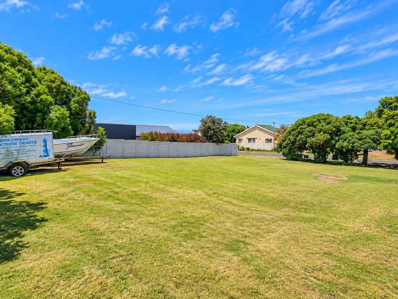 A spacious, well-maintained residential plot featuring a level lawn and secure precast concrete boundary walling.