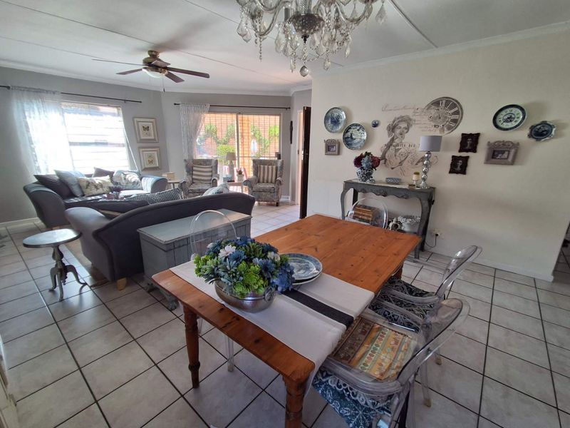 Spacious open-plan living and dining area featuring tiled flooring, a ceiling fan, and sliding glass doors leading to the exterior.