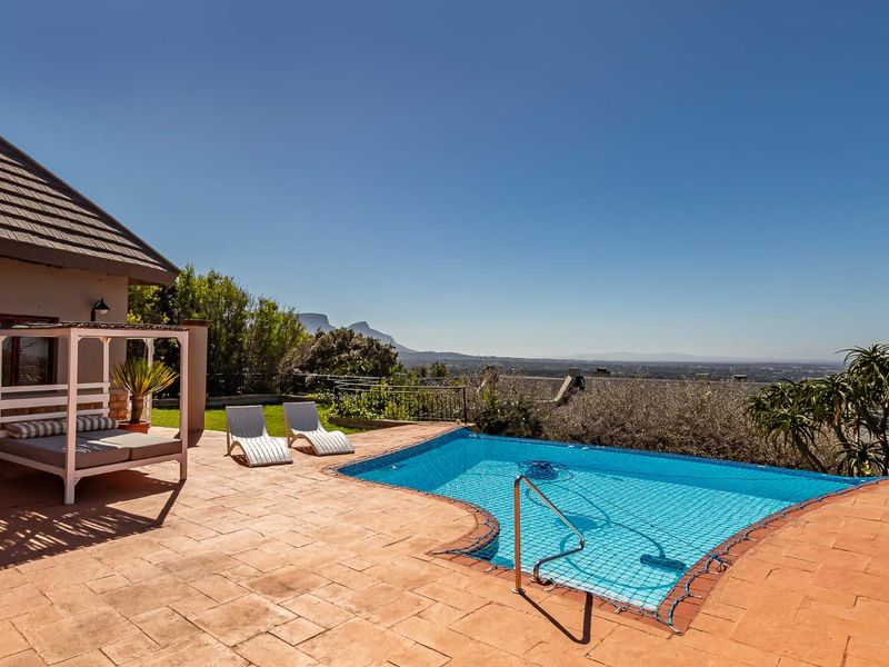 Outdoor pool area featuring a paved patio, safety net, and scenic mountain views, providing an ideal space for relaxation and entertainment.