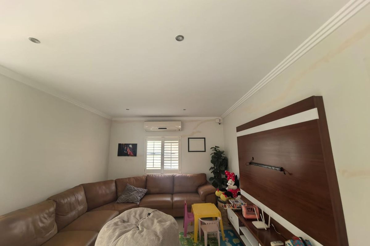Living room featuring crown molding, recessed lighting, a split-system air conditioner, plantation shutters, and a built-in media wall unit.