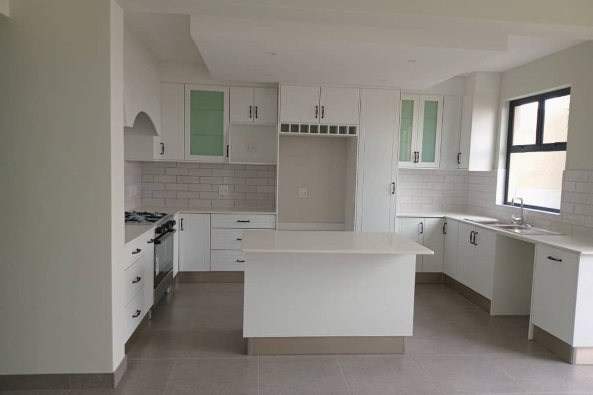 Modern kitchen featuring white cabinetry, stone countertops, a central island, subway tile backsplash, and a built-in gas stove with extractor fan.
