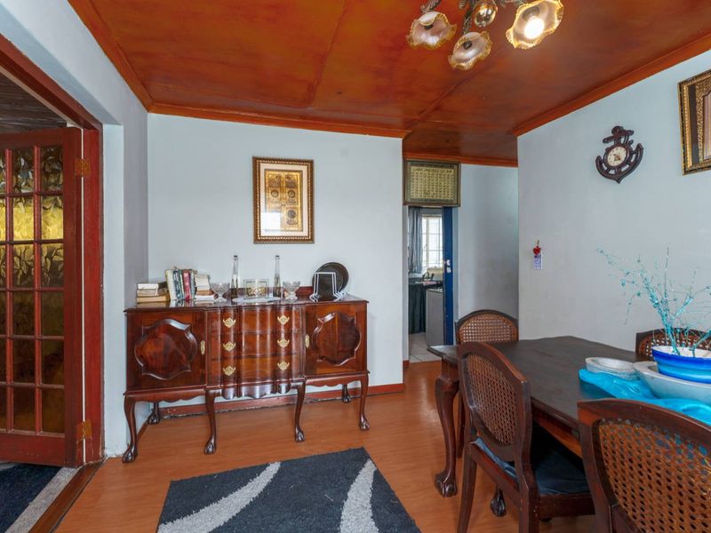 Dining room featuring laminate flooring and a timber ceiling, with direct access to adjacent living and kitchen areas.