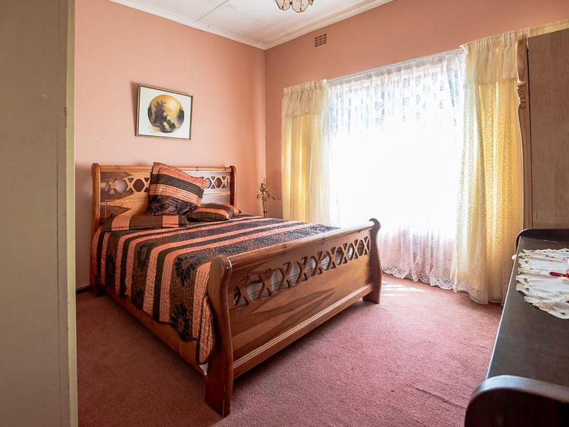 A bedroom featuring carpet flooring and a large window, presenting an opportunity for modernization through updated finishes and contemporary styling.
