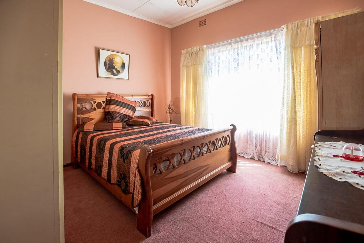 A bedroom featuring carpet flooring and a large window, presenting an opportunity for modernization through updated finishes and contemporary styling.