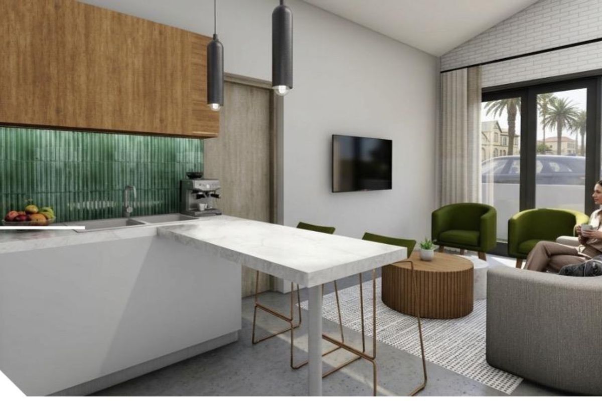 Modern open-plan living area featuring a contemporary kitchen with stone countertops, green tiled backsplash, and seamless flow to the outdoor patio area.