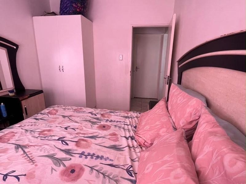 A bedroom featuring a built-in wardrobe and coving, currently presented with personal decor and furnishings.