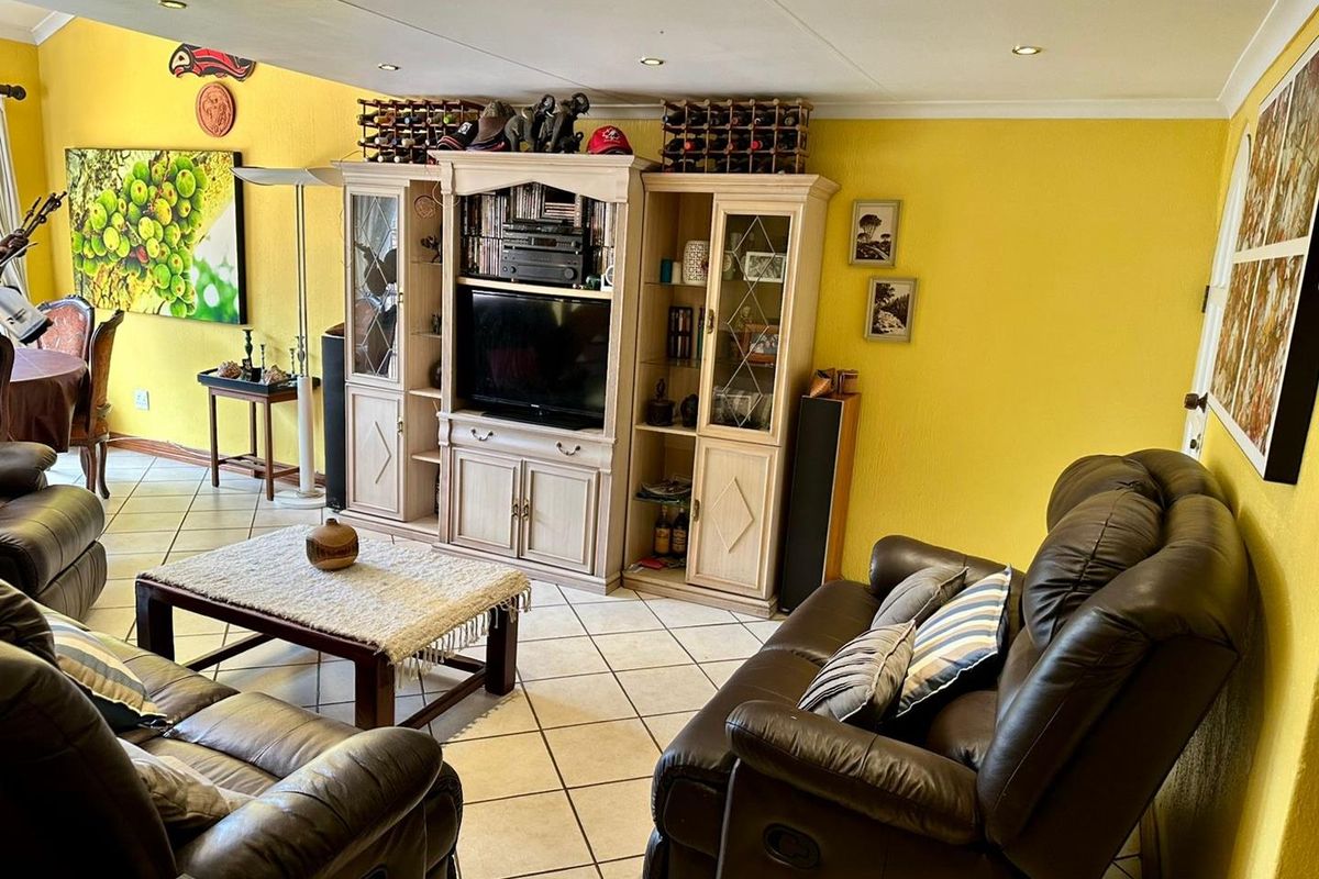 A spacious living room featuring tiled flooring and recessed ceiling lighting, providing a comfortable and functional area for relaxation.