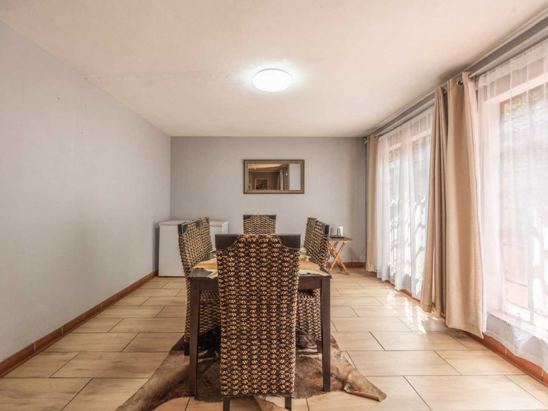 A dining room featuring tiled flooring and large sliding glass doors that provide natural light.