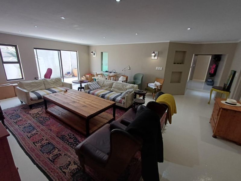 Spacious living room featuring polished concrete floors, recessed wall niches, and large sliding glass doors providing direct access to the outdoor patio area.