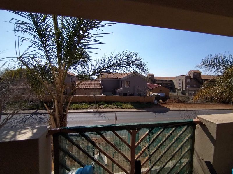 A balcony view overlooking a suburban street and neighbouring residential properties.